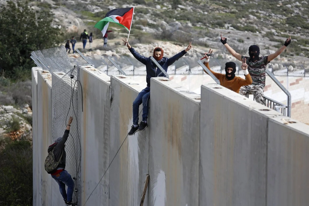 Palestinesi sopra il muro di separazione israeliano - Ap